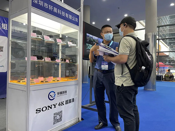 Wang Gong talks with customers consulting the exhibition